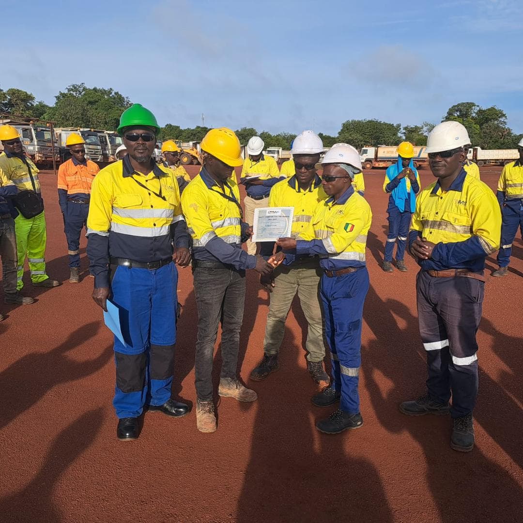 Remise d’une attestation à une équipe sur un chantier, en équipements de protection.