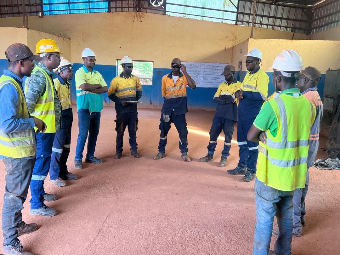 Briefing d'équipe avant intervention, en tenue de chantier.